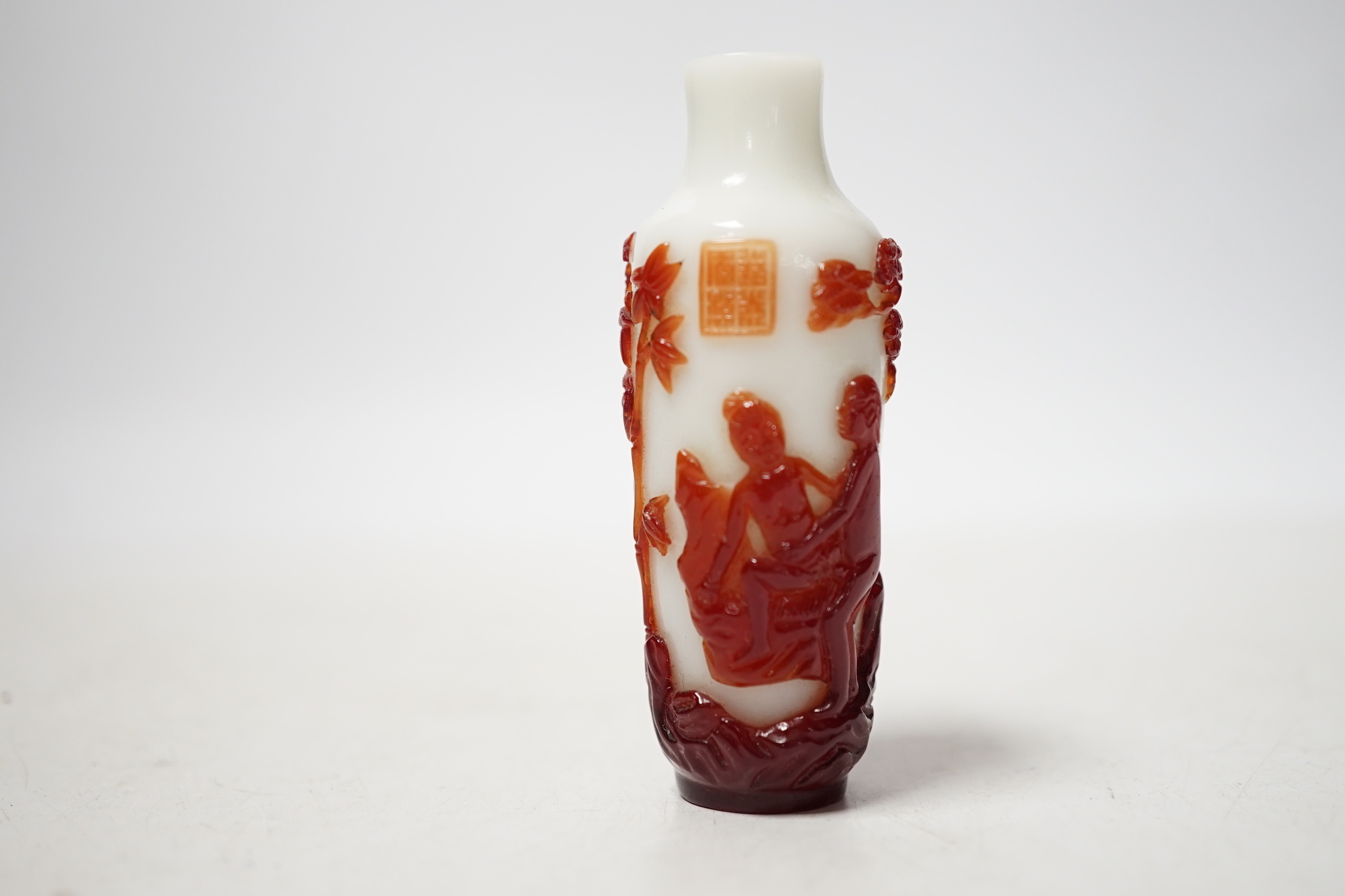 A Chinese ruby and white opaque glass erotic snuff bottle, early 20th century, 8cm high